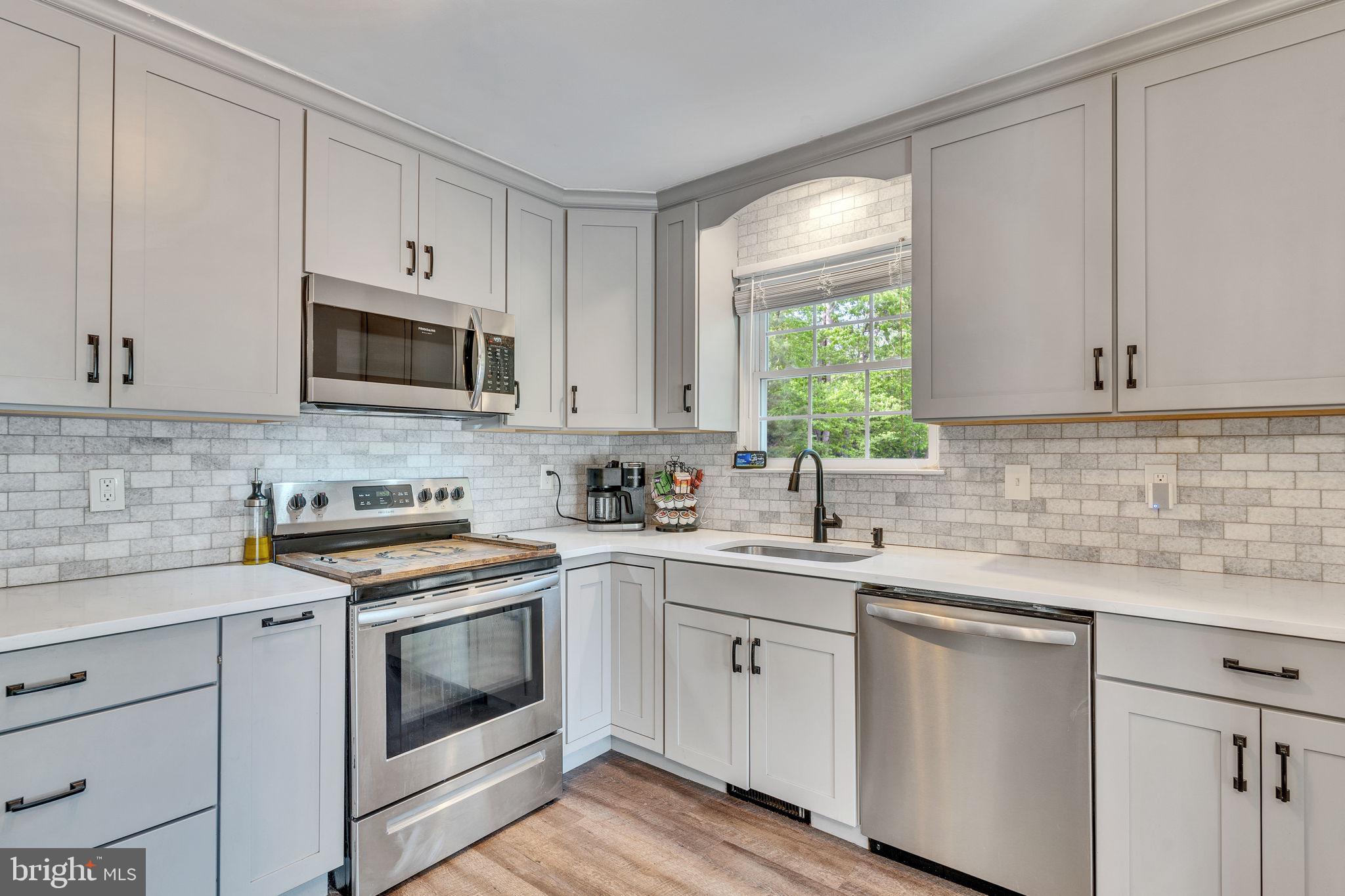 1195 Ball Road Port Republic, MD 20676 - Photo 7 of 23 a kitchen with white cabinets appliances a sink and a window