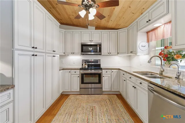 a kitchen with a stove a sink and a refrigerator