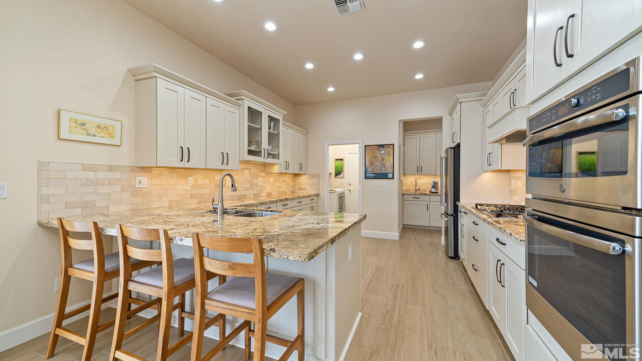 2085 Tesuque Court Reno, NV 89511 - Photo 17 of 40 a kitchen with granite countertop kitchen island stainless steel appliances a stove refrigerator sink and cabinets
