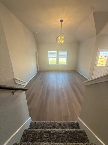 an empty room with windows and ceiling fan
