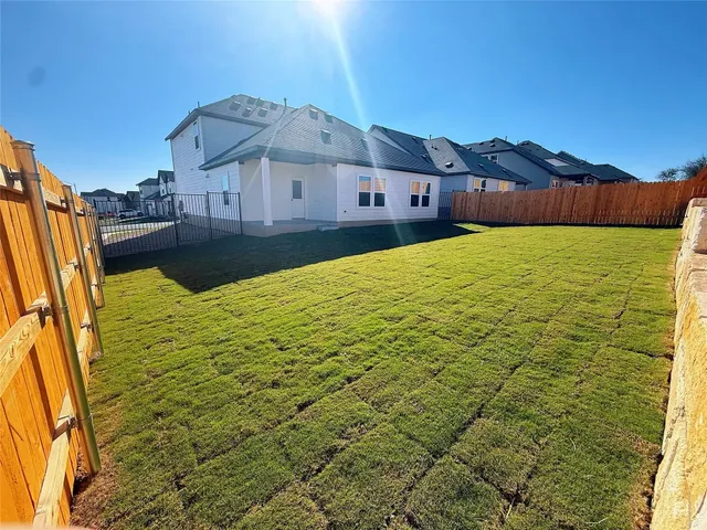 a view of a house with pool and a yard