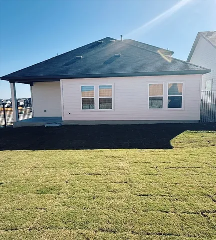 an empty room with wooden floor cabinet and windows