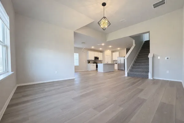 an empty room with wooden floor and stairs