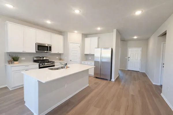 a large kitchen with stainless steel appliances granite countertop a stove a sink and a refrigerator