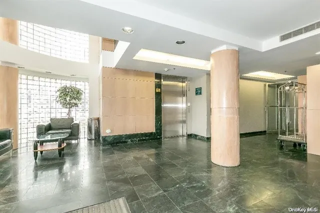 a view of a hallway with wooden floor and a bathroom