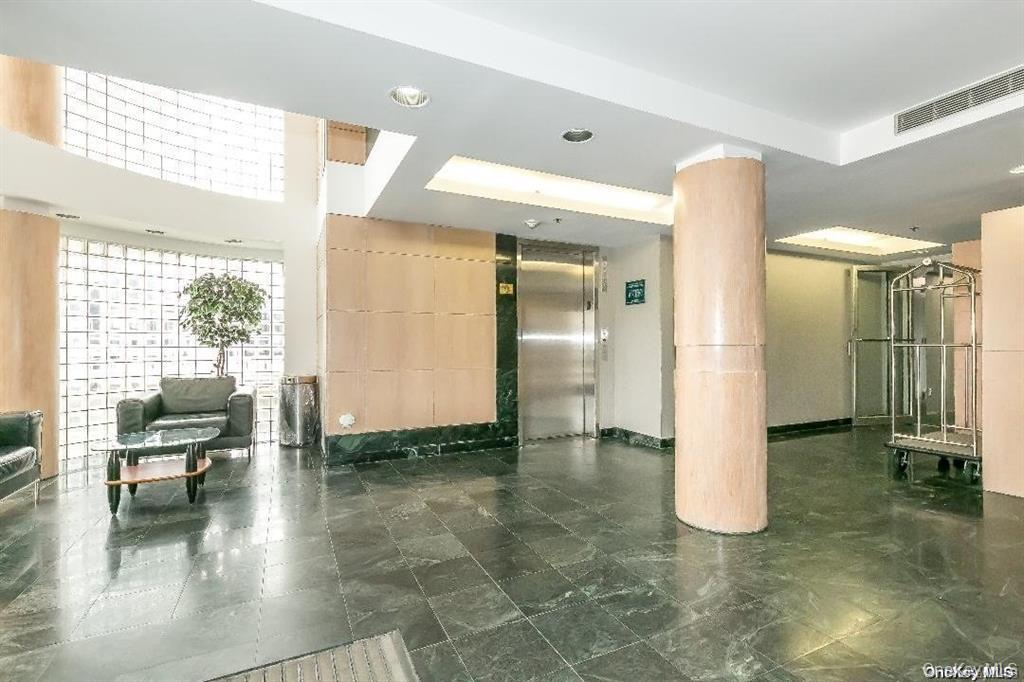 88 Cutter Mill Road, Unit 112 Great Neck, NY 11021 - Photo 3 of 12 a view of a hallway with wooden floor and a bathroom