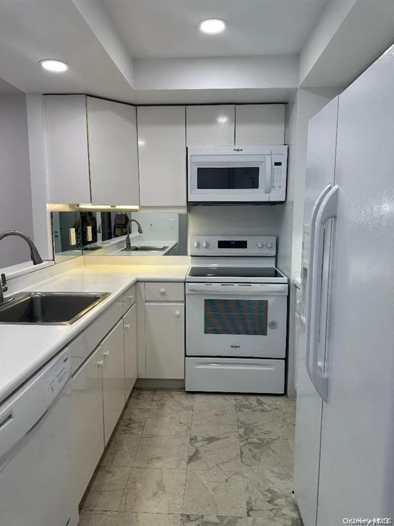 88 Cutter Mill Road, Unit 112 Great Neck, NY 11021 - Photo 7 of 12 a kitchen with a sink a stove and cabinets