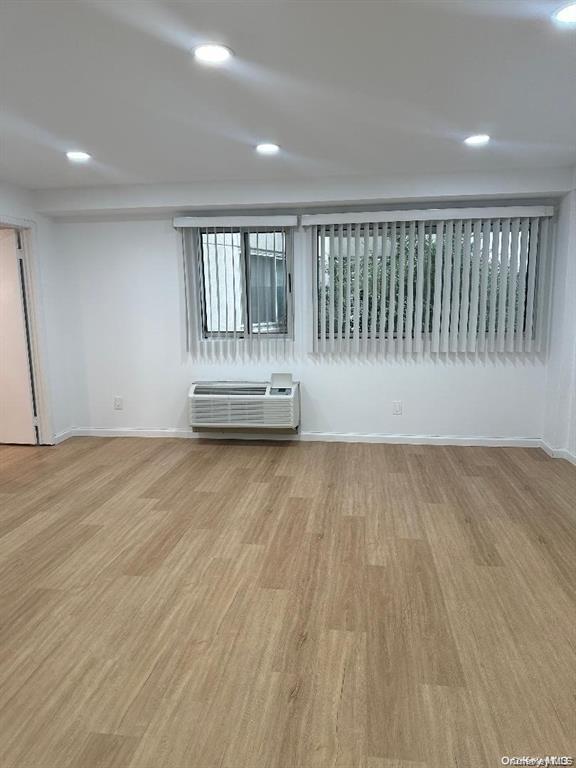 88 Cutter Mill Road, Unit 112 Great Neck, NY 11021 - Photo 9 of 12 an empty room with wooden floor and windows