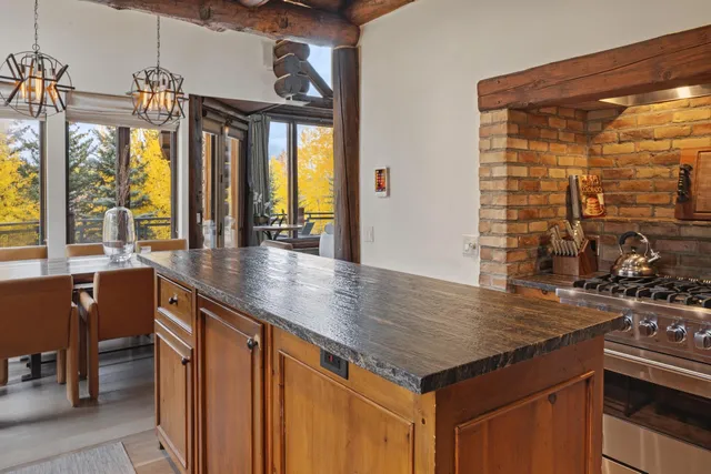 an open kitchen with a sink and large windows