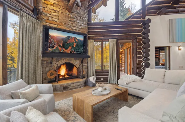 a living room with furniture a fireplace and a large window
