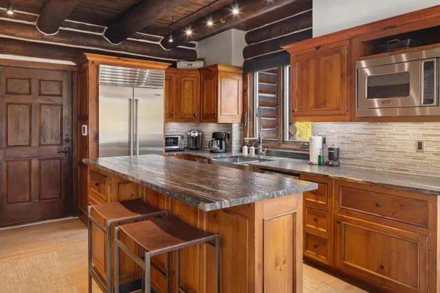 a kitchen with stainless steel appliances granite countertop a sink a stove and cabinets