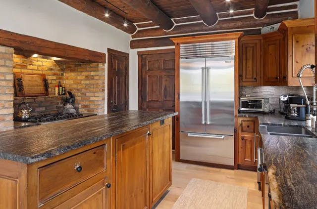 a kitchen with stainless steel appliances granite countertop a refrigerator and a sink