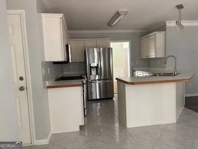 a kitchen with stainless steel appliances granite countertop a refrigerator sink and stove