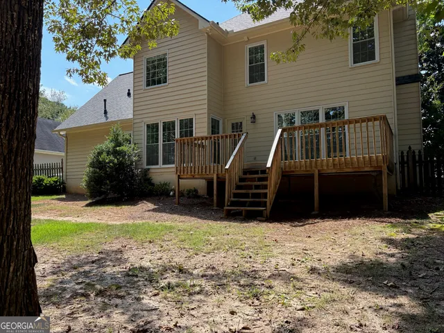 a view of a house with backyard and sitting area