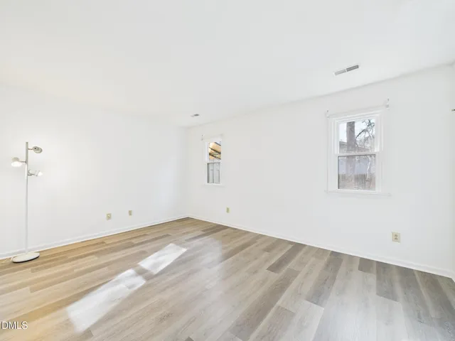 a view of empty room with wooden floor