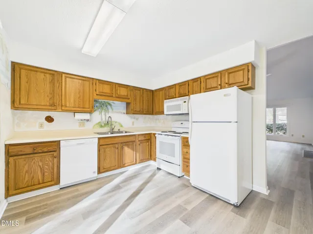 a kitchen with a refrigerator a stove a sink and cabinets