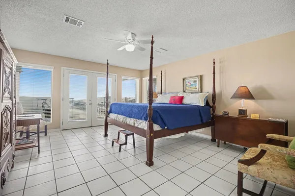 a spacious bedroom with a bed and a chandelier