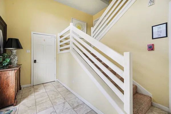 a view of a hallway with entryway and stairs