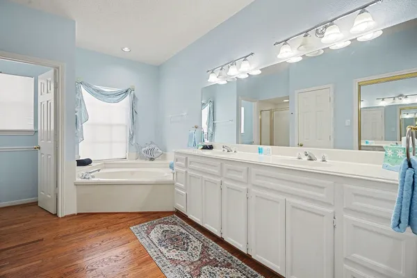 a spacious bathroom with a double vanity sink and a mirror