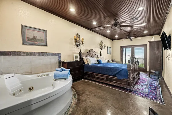 a spacious bedroom with a bed and a chandelier