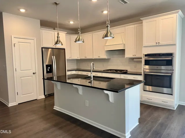 a kitchen with stainless steel appliances a stove microwave and sink