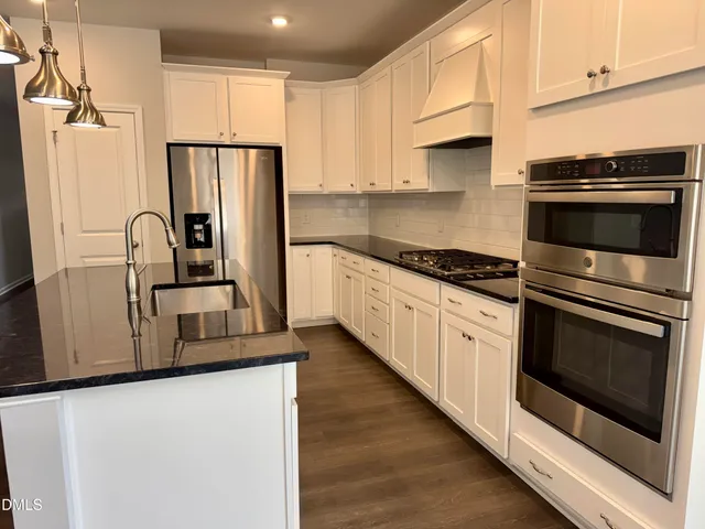 a kitchen with granite countertop white cabinets and a dishwasher