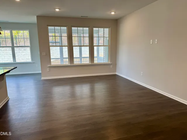an empty room with wooden floor and a window
