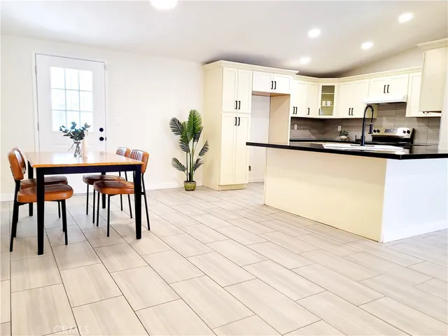a kitchen with stainless steel appliances kitchen island granite countertop a refrigerator and cabinets