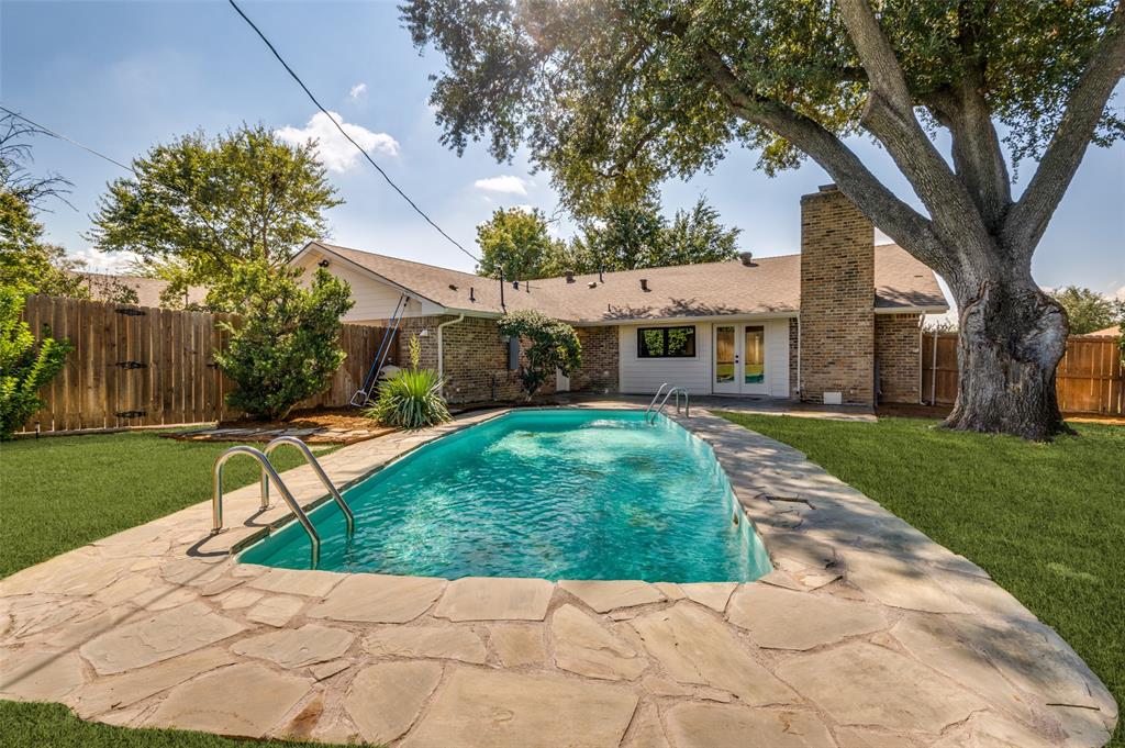 3161 Lockmoor Lane Dallas, TX 75220 - Photo 23 of 25 a view of a white house with a yard plants and a large tree