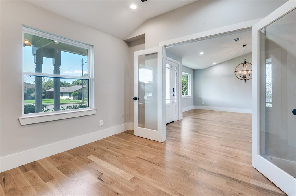 3161 Lockmoor Lane Dallas, TX 75220 - Photo 5 of 25 a view of an empty room with wooden floor and a window