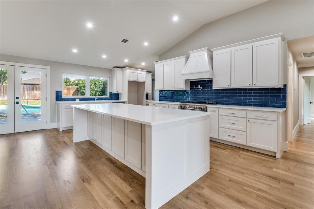 3161 Lockmoor Lane Dallas, TX 75220 - Photo 8 of 25 a kitchen with stainless steel appliances granite countertop a stove a sink and white cabinets with wooden floor