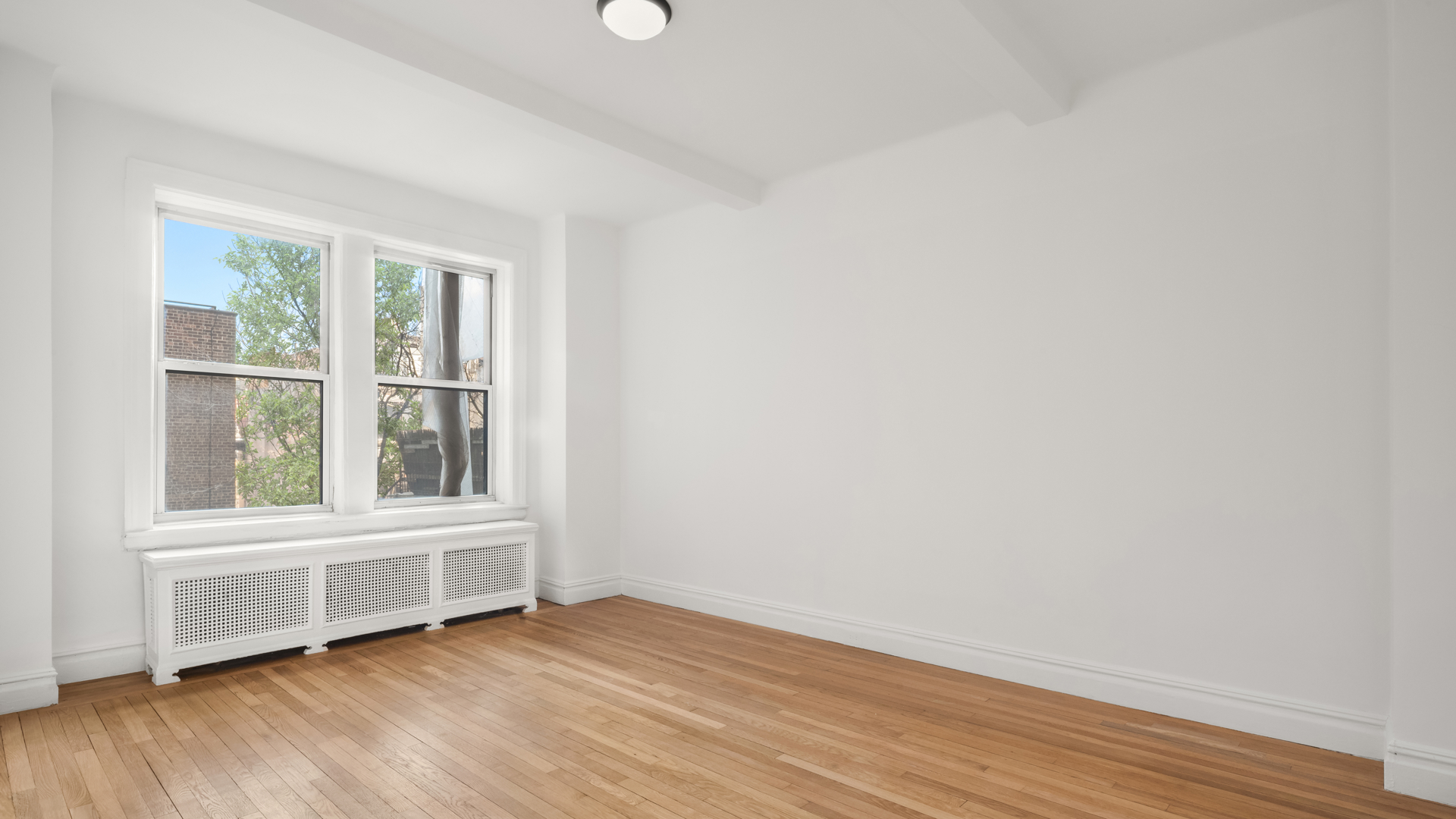 340 Riverside Drive, Unit 6D Manhattan, NY 10025 - Photo 12 of 26 an empty room with wooden floor and windows