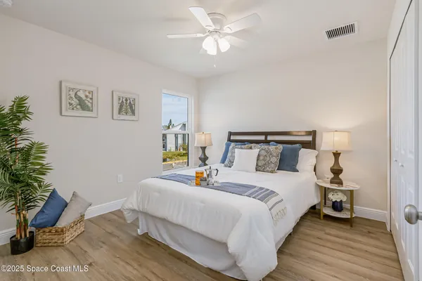 a bedroom with bed and a potted plant