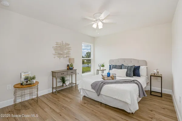 a bedroom with a bed and a table with wooden floor