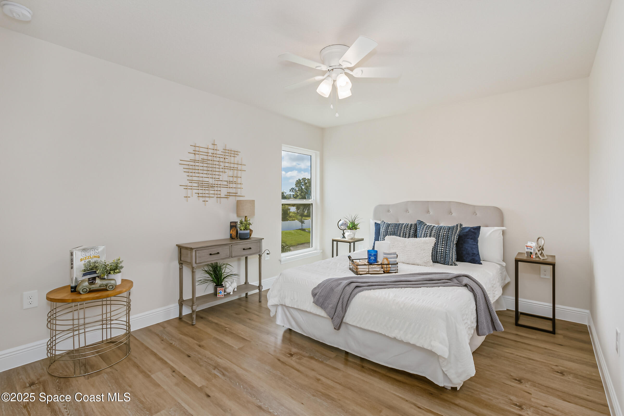 187 Hidden Woods Place Melbourne, FL 32901 - Photo 24 of 40 a bedroom with a bed and a table with wooden floor
