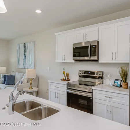 a kitchen with stainless steel appliances a stove a sink a microwave and cabinets