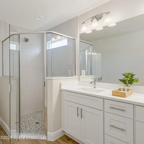a bathroom with a shower sink and mirror