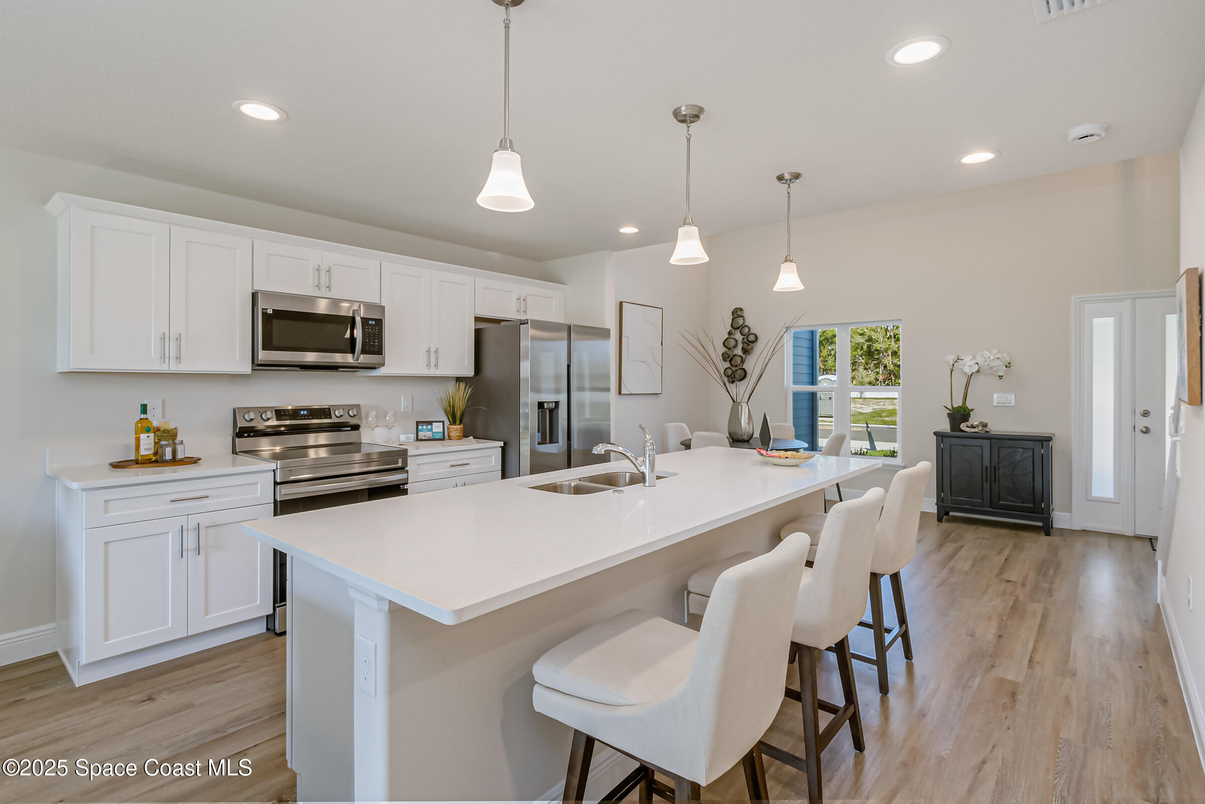 187 Hidden Woods Place Melbourne, FL 32901 - Photo 5 of 40 a kitchen with stainless steel appliances granite countertop a stove a sink a microwave a refrigerator a center island and furniture