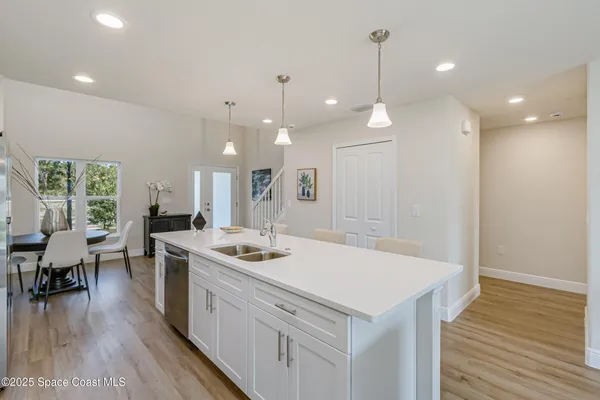 a kitchen that has a lot of cabinets a sink and wooden floor