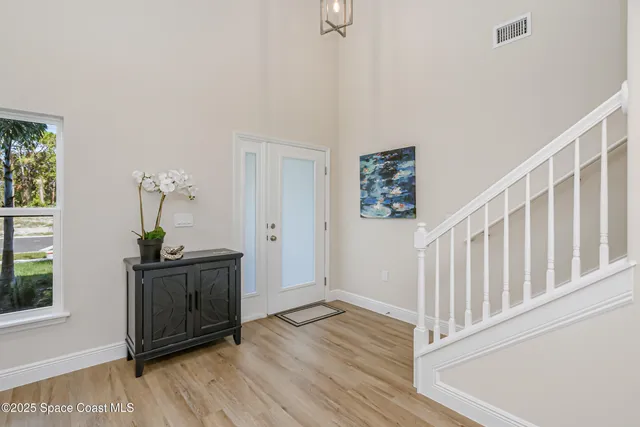 a view of a hallway with wooden floor and stairs