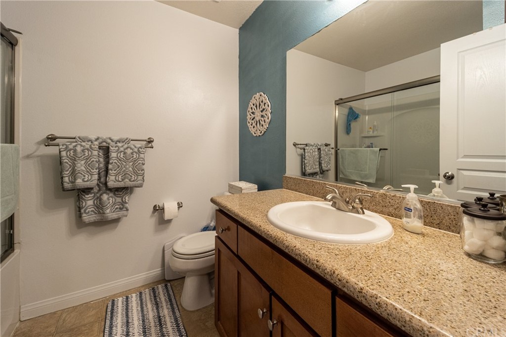 180 Chambers Street, Unit 28 El Cajon, CA 92020 - Photo 13 of 22 a bathroom with a granite countertop sink a toilet and a mirror