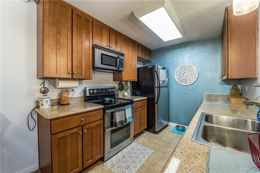 180 Chambers Street, Unit 28 El Cajon, CA 92020 - Photo 8 of 22 a kitchen with stainless steel appliances granite countertop a sink stove and refrigerator