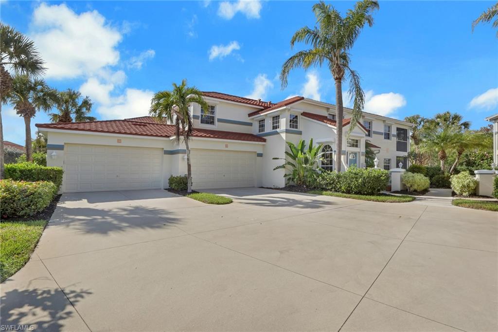 10801 Crooked River Road, Unit 203 Estero, FL 34135 - Photo 2 of 27 a front view of a house with a yard and garage
