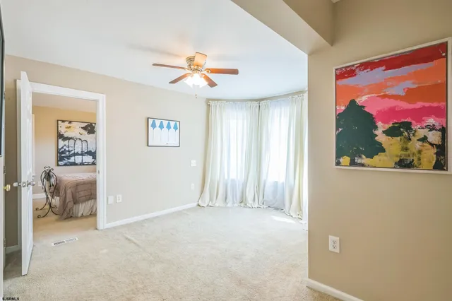 a view of a livingroom with wooden floor and a ceiling fan