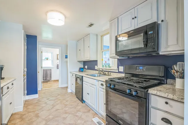 a kitchen with stainless steel appliances granite countertop a stove and a microwave