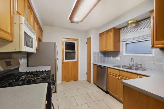 a spacious bathroom with a granite countertop sink a mirror and a bathtub