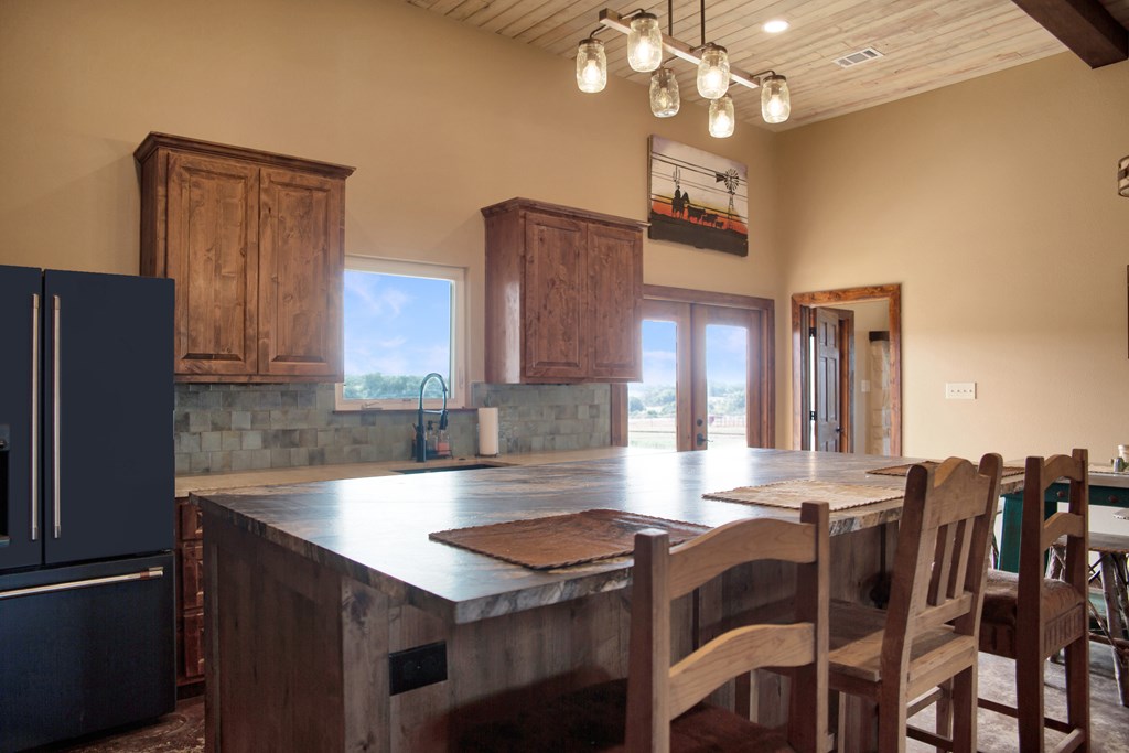 4252 Cypress Mill Road Johnson City, TX 78636 - Photo 16 of 47 a kitchen with cabinets table and chairs