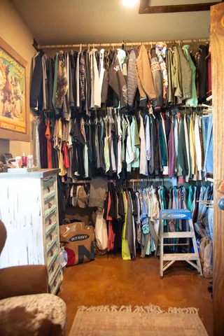 a view of walk in closet with clothes and shoes
