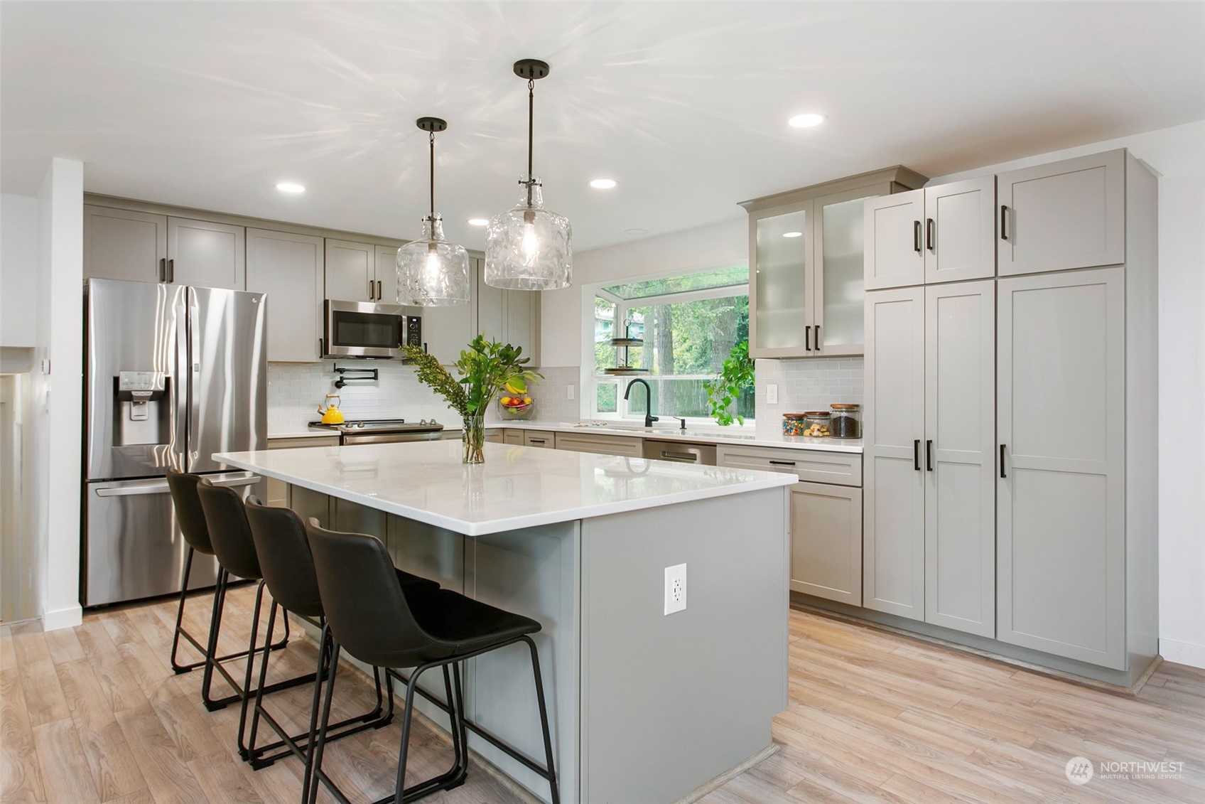 205 155th Place Southeast Bothell, WA 98012 - Photo 5 of 37 a kitchen with stainless steel appliances kitchen island granite countertop a refrigerator a sink dishwasher a stove with white cabinets and wooden floor