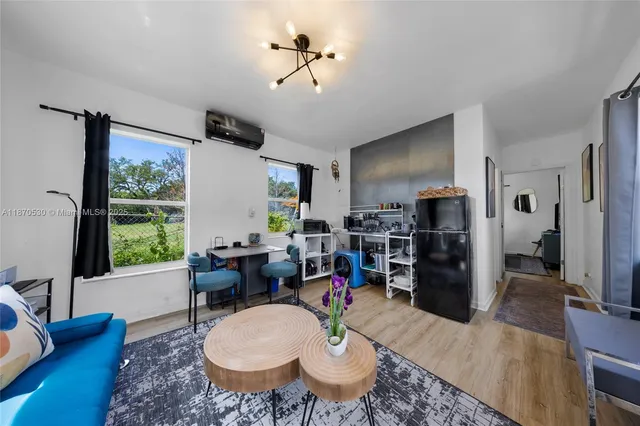 a living room with furniture a large window and stainless steel appliances
